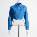 Detailansicht der blauen kurzen Jeansjacke mit weißen Kontrastnähten und Kragen - S / Oberteile / Blau