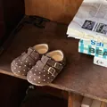 Detailansicht von braunen Wildleder-Babyschuhen mit Punkten auf einem Vintage-Holzregal - Größe 22 Innen 15.1cm / Braun