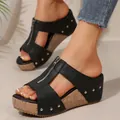 Detail view of women's black wedge sandals featuring front zipper and silver studs. - 36 / Zipper Style / Black