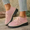 Dettaglio di scarpe casual fly-knit rosa con spessa suola platform su pavimento di legno - Rosa
