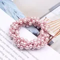 Detailed close-up of elegant pink faux pearl beads on a sweet elastic hair scrunchie - Pink