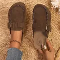 Gros plan de mules en daim marron avec boucle métallique et coutures décoratives. - 35 / Marron