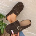 Detailed view of dark brown suede clogs featuring a stylish gold buckle and braided stitching - 36 / Coffee