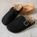 Close-up view of black closed-toe clogs featuring adjustable buckle and cork texture sole - 36-37 / Black