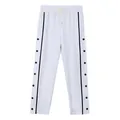 Front view of white loose-fit tear-away trousers with black snap button details - S / Bottoms / White