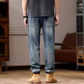 Loose fit stretch denim pants in classic blue shown from the back with worker boots - Vintage Blue