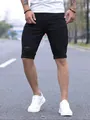 Detail view of men's distressed black denim shorts with ripped details and rolled cuffs - S / Bottoms / Black