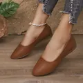 Primo piano di scarpe basse marroni in pelle a punta con texture morbida ed elegante - 35 / Marrone scuro