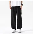 Close-up of men's loose black straight-leg jeans featuring a clean minimalist design - S / Bottoms / Black