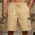 Detail view of men's khaki cargo shorts with elastic drawstring waist and side pockets. - S / Bottoms / Dark Khaki