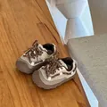 Detaillierte Nahaufnahme von cremefarbenen und braunen Kleinkind-Sneakern auf einer Holzfläche - Größe 18 Innenlänge 13.4cm / Khaki