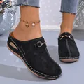 Detail view of black wedge mules featuring hollow-out floral pattern and metal buckle - 36 / Black