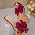 Elegant burgundy bow sandals featuring clear PVC straps and a stylish wine glass heel - Burgundy