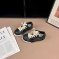 Detail showing black retro children's board shoes with white stitching and laces - 26 / Black