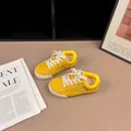 Close-up detail of yellow retro kids sneakers with cream laces and soft sole - 26 / Yellow