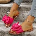 Detailweergave van roze slippers met strik, comfortabel stoffen bovenwerk en ronde neus - 36 / Rozerood