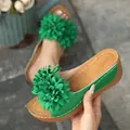 Gros plan de sandales à plateforme compensée vertes avec grande fleur en tissu - 36 / Vert