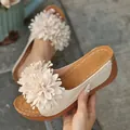 Vue détaillée de mules compensées beige avec une grande fleur en tissu. - 36 / Blanc Cassé