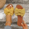 Primer plano de las sandalias planas amarillas con un gran lazo decorativo de tela - Amarillo