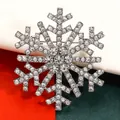 Detailed macro shot of a sparkling silver snowflake brooch with clear rhinestones - Silver