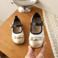 Gros plan d'une chaussure de princesse crème pour fille avec bout doré et nœud élégant - 21*13 / Champagne