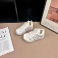 Détail de baskets argentées pour enfants avec boucle rotative et maille filet - 26 / Blanc Cassé