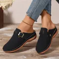 Close-up of black women's wedge mules with buckle strap and white stitching details - 36 / Black