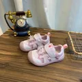 Roze peutersneakers met schattig strikje en klittenbandsluiting op houten tafel - Roze