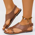 Nahaufnahme flacher brauner Römersandalen mit Klettverschluss und Zehenschlaufe - Braun