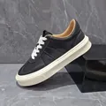 Classic black leather sneakers for men featuring thick white soles and contrasting white laces - Black