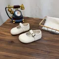 Detailansicht der weißen Vintage Mary Jane Kinderschuhe auf einem rustikalen Holztisch. - Gebrochenes Weiß