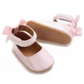 Gros plan de chaussures roses pour bébé fille avec bride perlée et semelle antidérapante - Rose