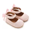 Detail der rosa Satin-Babyschuhe mit Perlenspitze und einer Schleife - Rosa