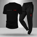 Détail du survêtement de sport noir avec texte 'PARIS' et bande dégradée rouge - S / Haut Et Bas / Manches Courtes & Pantalon / Noir
