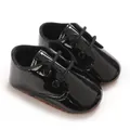 Primo piano di scarpine da neonato in vernice nera con suole morbide antiscivolo e lacci. - Stile Nero Lucido (C-932C)