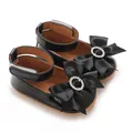 Elegante schwarze Lacklederschuhe für Babys mit großer Schleife und einem Strassring. - Schwarz