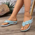 Dettaglio di sandali infradito con zeppa azzurri e fiori su pavimento in legno - 36 / Azzurro