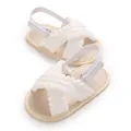 Vista detallada de sandalias blancas para bebé con lindos pompones y velcro - Blanco