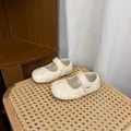 Detailed view of cream quilted leather children's Mary Jane shoes with pearl strap - Off White