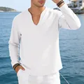 Close-up of men's casual white linen long-sleeve V-neck t-shirt by the sea. - White
