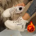 Dettaglio di stivali invernali beige foderati in pile con suola spessa ed etichetta laterale. - Bianco avorio