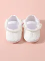 Elegante weiße Baby-Prinzessin-Schuhe aus Spitze mit Perlenband und einer kleinen Schleife - Naturweiß