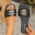 Close-up of black summer flat sandals featuring an elegant interlocking gold metal chain - 35 / Black