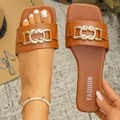 Close-up of brown flat sandals with a stylish gold chain link buckle on a square toe - 35 / Brown