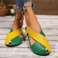 Close-up of vibrant green and yellow crossover flat Roman sandals on a model's feet - Yellow-Green