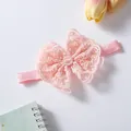 Close-up of delicate pink lace bow baby headband with elegant pearl center ornament - 0-3 Years Old / Ivory