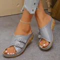 Detailed view of grey wedge sandals with adjustable double buckles and open toe design - Gray