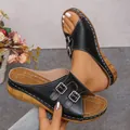 Detailed view of women's black wedge sandals featuring double buckle and peep toe. - Black