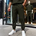 Detalle de pantalones deportivos para hombre verde oliva con textura en un entorno urbano real. - S / Bottoms / Verde Militar