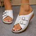 Elegant white wedge sandals featuring double buckle straps and detailed hollow out patterns - White